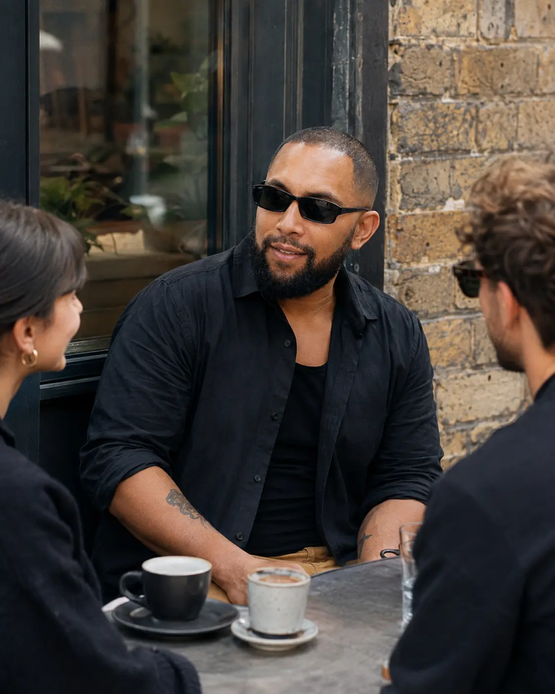 Tigz in conversation with two people outside a London café